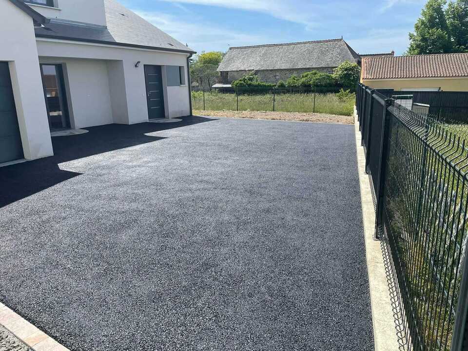 Travaux d'aménagement extérieur réalisés par une entreprise de travaux publics à Richelieu, mettant en avant la pose d'enrobé pour une entrée de maison.